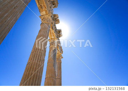 Exploring Ancient Architecture: Majestic Columns Under a Clear Blue Sky with a Brilliant Sunlight Backdrop Exploring Ancient Architecture: Majestic Columns Under a Clear Blue Sky with a Brilliant Sunlight Backdrop 132131568