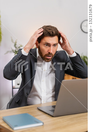 Middle-aged businessman sees laptop freeze eyes widen press key reboots system upset data loss after Middle-aged businessman sees laptop freeze eyes widen press key reboots system upset data loss after 132131679