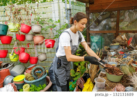 A Dedicated Young Gardener Engaging in Flourishing Work at a Vibrant Plant Nursery 132131689