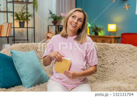 Pregnant woman writing future letter for baby placing envelope on belly smiling hopeful sweet hope 132131704