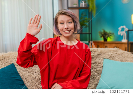 Young woman happily waving hand hello gesture friendly cheerful greeting expression smiling joyfully Young woman happily waving hand hello gesture friendly cheerful greeting expression smiling joyfully 132131771