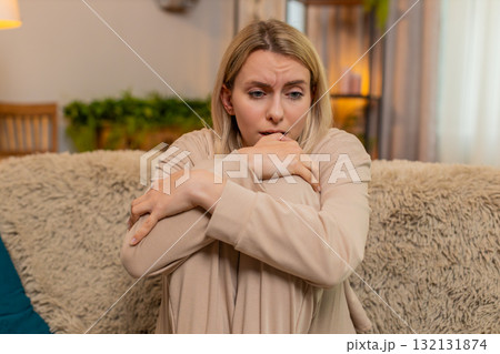Adult sad woman showing visible stress, tension and emotional irritated, fatigue at home on sofa Adult sad woman showing visible stress, tension and emotional irritated, fatigue at home on sofa 132131874