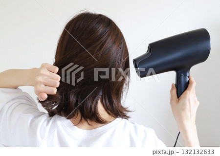 ドライヤーで髪を乾かす女性 132132633