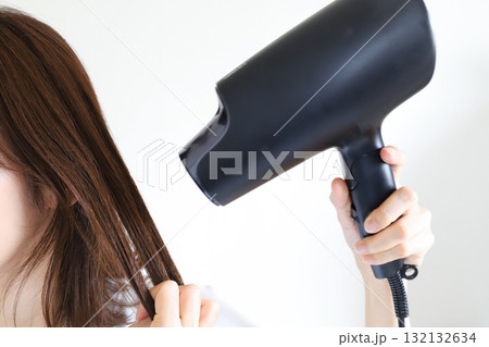 ドライヤーで髪を乾かす女性 132132634