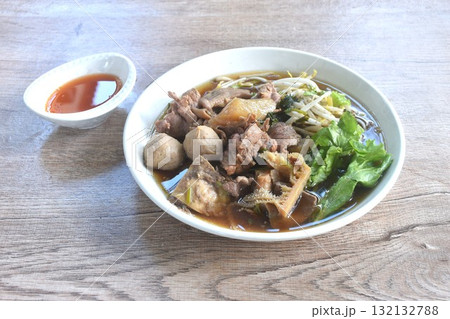 boiled braised beef meat and tendon couple organ in herb brown soup on plate dipping spicy chili sauce  132132788