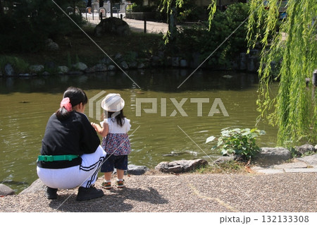 京都・円山公園のひょうたん池のほとりでたたずむ母と娘 132133308