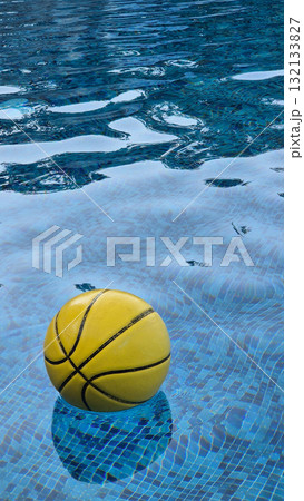 Yellow basketball floating on water surface in swimming pool 132133827