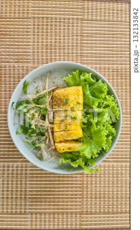 Thai rice congee with egg rolls and fresh herbs in bowl Thai rice congee with egg rolls and fresh herbs in bowl 132133842