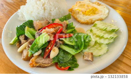 Thai Stir-fried Baby Cabbage with Pork Belly served with rice and fried egg on white plate 132133858
