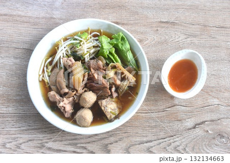boiled braised beef meat and tendon couple organ in herb brown soup on plate dipping spicy chili sauce  132134663