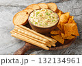 Homemade Deviled Egg Dip sauce with chips, breadsticks and biscuit close-up in a plate. Horizontal 132134961