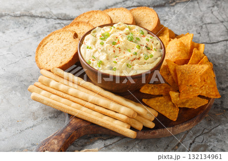Homemade Deviled Egg Dip sauce with chips, breadsticks and biscuit close-up in a plate. Horizontal Homemade Deviled Egg Dip sauce with chips, breadsticks and biscuit close-up in a plate. Horizontal 132134961