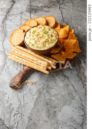 Deviled Egg Dip with chips, breadsticks, and a biscuit close-up in a plate. Vertical Deviled Egg Dip with chips, breadsticks, and a biscuit close-up in a plate. Vertical 132134963