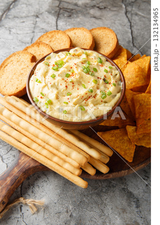 Tasty Deviled Egg Dip with nachos, breadsticks, and toast close-up in a plate. Vertical Tasty Deviled Egg Dip with nachos, breadsticks, and toast close-up in a plate. Vertical 132134965