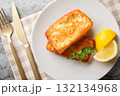 Saganaki is a Greek delicacy of fried cheese with a lemon wedge close-up in a plate. Horizontal top view 132134968