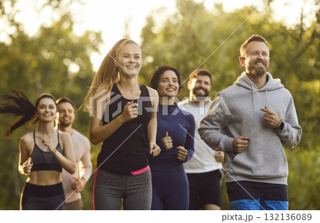 Active young people in sportswear running together in park, having training in nature Active young people in sportswear running together in park, having training in nature 132136089