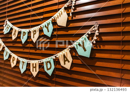 木製ブラインドに飾られたハッピーバースデーのガーランド 132136493