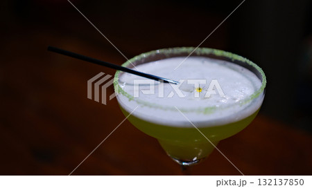 Margarita in a blue rimmed glass with lime on a wooden surface 132137850