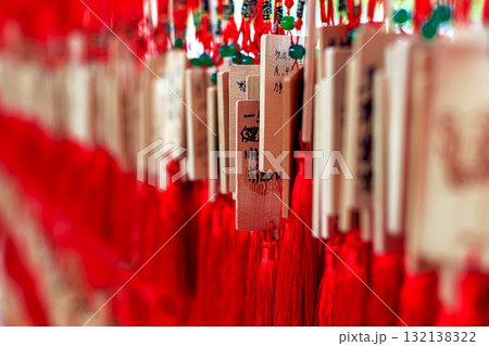 Wooden signs with Chinese characters and dragon designs, decorated with bright red tassels 132138322