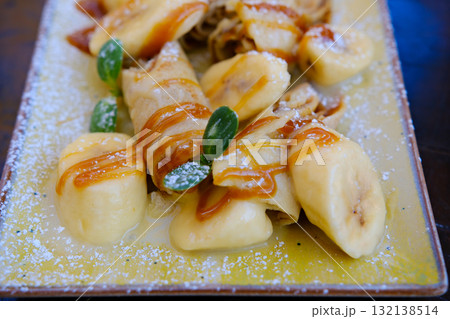 Crepes bananas caramel Crepes stuffed with chocolate spread and banana on white plate. Thin pancakes, blini. Sweet dessert. Crepes bananas caramel Crepes stuffed with chocolate spread and banana on white plate. Thin pancakes, blini. Sweet dessert. 132138514
