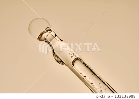 The texture of the hyaluronic serum flowing down the dropper. The texture of the hyaluronic serum flowing down the dropper. 132138989