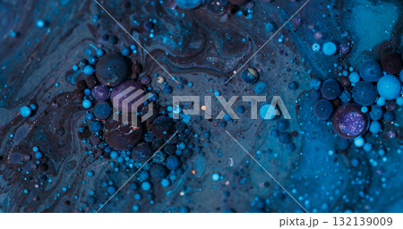 Oil stream. Bubble fluid. Defocused blue purple color round glitter paint acrylic wet texture floating on abstract vibrant background. 132139009