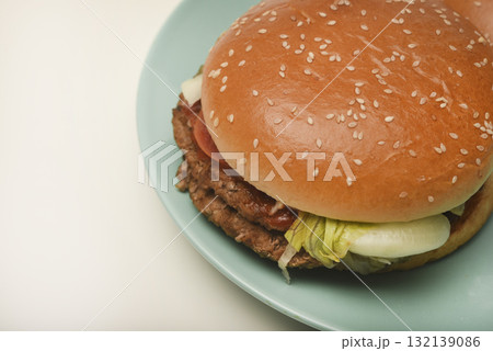 Hamburger with meat and vegetables. Fast food. Hamburger on a plate. Hamburger with meat and vegetables. Fast food. Hamburger on a plate. 132139086