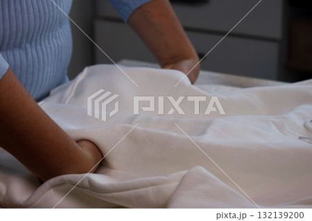 Woman reviewing a white hoodie Checking the pockets 132139200