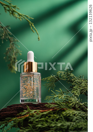 Glass cosmetic serum bottle on natural background with green leaves Glass cosmetic serum bottle on natural background with green leaves 132139626