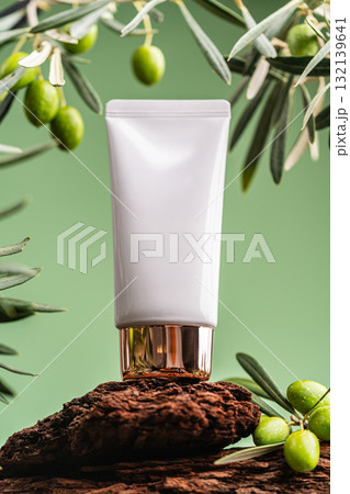 Sunscreen tube with olive branches and olive oil on green background, natural skincare concept Sunscreen tube with olive branches and olive oil on green background, natural skincare concept 132139641