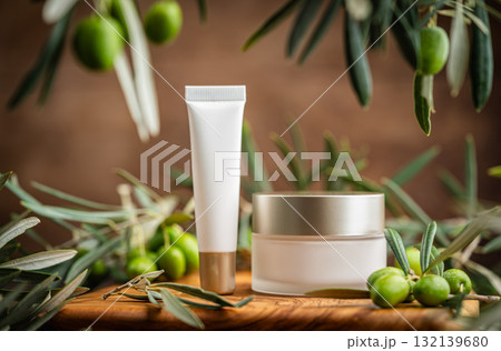Natural skincare cosmetics with olive oil and peptides on wooden board with fresh olives 132139680