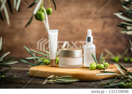 Natural skincare cosmetics with olive oil and peptides on wooden board with fresh olives Natural skincare cosmetics with olive oil and peptides on wooden board with fresh olives 132139696