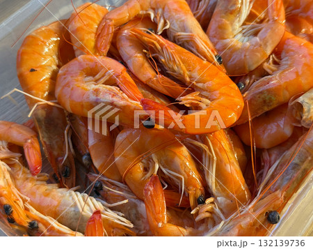Boiled orange shrimps arranged inside a clear box. Freshness, seafood, and summer meal highlighting natural marine produce and culinary enjoyment. Boiled orange shrimps arranged inside a clear box. Freshness, seafood, and summer meal highlighting natural marine produce and culinary enjoyment. 132139736