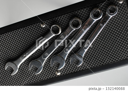 Steel spanners are laid out in ascending order of diameter on a rubber napkin. Hand tools arrangement in order stock photo 132140088