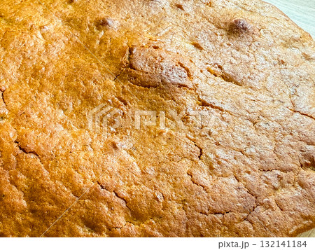 Golden crust with cracks and texture from baking. Warmth, comfort, and homemade simplicity reflecting cozy domestic moments and natural imperfection. Golden crust with cracks and texture from baking. Warmth, comfort, and homemade simplicity reflecting cozy domestic moments and natural imperfection. 132141184