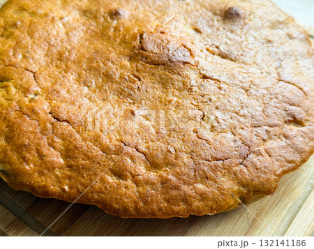 Golden crust with cracks and texture from baking. Warmth, comfort, and homemade simplicity reflecting cozy domestic moments and natural imperfection. 132141186