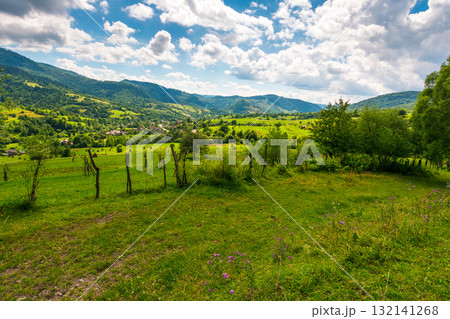rural fields on rolling hills of ukraine in summer. wide angle countryside landscape of transcarpathia with stick fences in dappled light. uzhok village down in the valley. slow living in carpathians 132141268