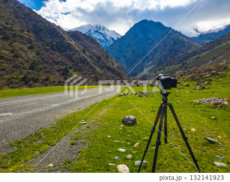 Camera on tripod capturing serene mountain landscape Camera on tripod capturing serene mountain landscape 132141923