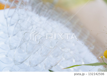Array of clear champagne glasses neatly organized in rows. The glasses create an elegant and sophisticated atmosphere, perfect for celebrations and formal events 132142506