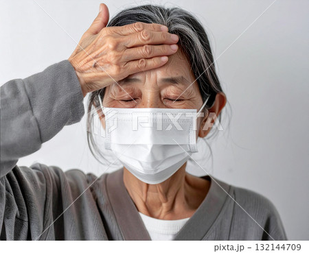 風邪をひいて発熱で苦しむ高齢女性	 132144709