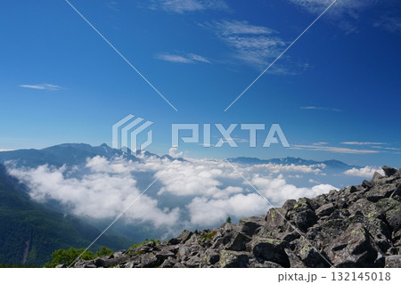 青空を背景に蓼科山の山頂ガレ場と白雲流れる八ヶ岳から南アルプスのパノラマ風景　Ver1 132145018