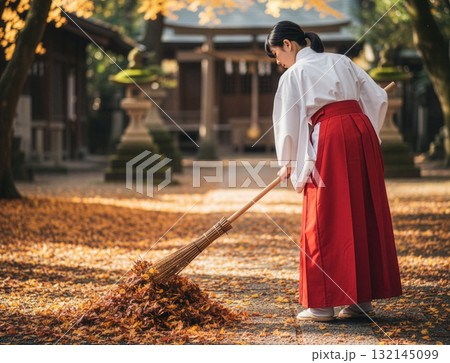 日本の美しい秋:紅葉舞う神社で落ち葉を掃く巫女の姿 日本の美しい秋:紅葉舞う神社で落ち葉を掃く巫女の姿 132145099