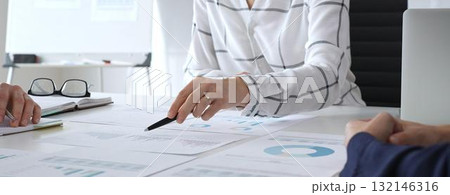 A business meeting with colleagues in a modern office where financial schedules, work planning, and reports are discussed in a team effort A business meeting with colleagues in a modern office where financial schedules, work planning, and reports are discussed in a team effort 132146316