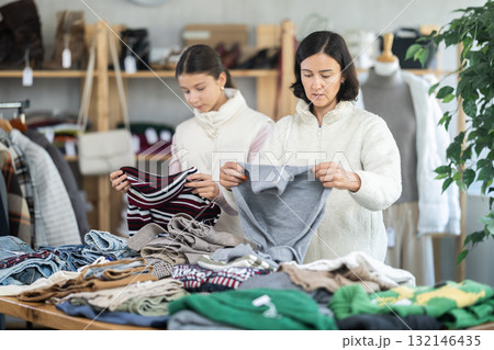 Adult woman and teenage girl choose sweater 132146435