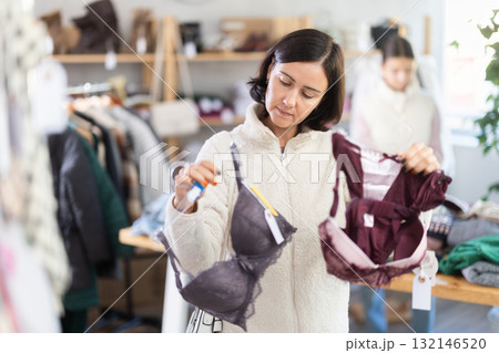 Woman looks at products in store and selects bra. Family shopping 132146520