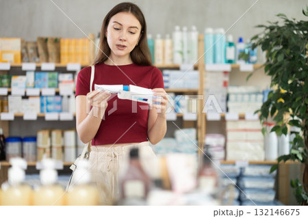 Woman choosing an ointment at the pharmacy Woman choosing an ointment at the pharmacy 132146675