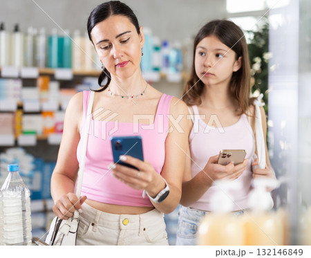 woman and her daughter came to the pharmacy for shopping 132146849