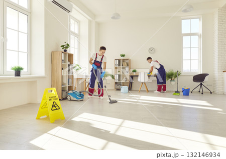 Group of young happy male people in uniform wiping, washing and vacuuming client house or office. Group of young happy male people in uniform wiping, washing and vacuuming client house or office. 132146934