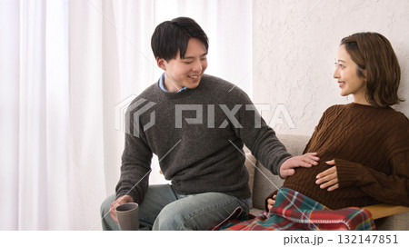 ソファに座ってくつろぐ若い夫婦 妊婦さん ソファに座ってくつろぐ若い夫婦 妊婦さん 132147851