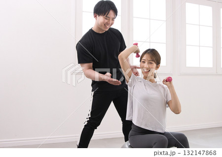 パーソナルトレーナーにトレーニングを受ける若い女性 パーソナルトレーナーにトレーニングを受ける若い女性 132147868